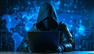cyber criminal with dark hood on computer-1