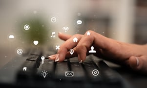 Business woman hand typing on keyboard with application icons around