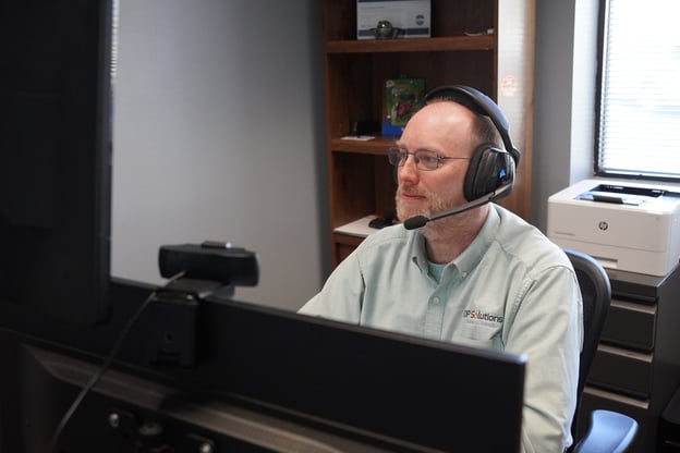 Engineer on computer and headset in an office