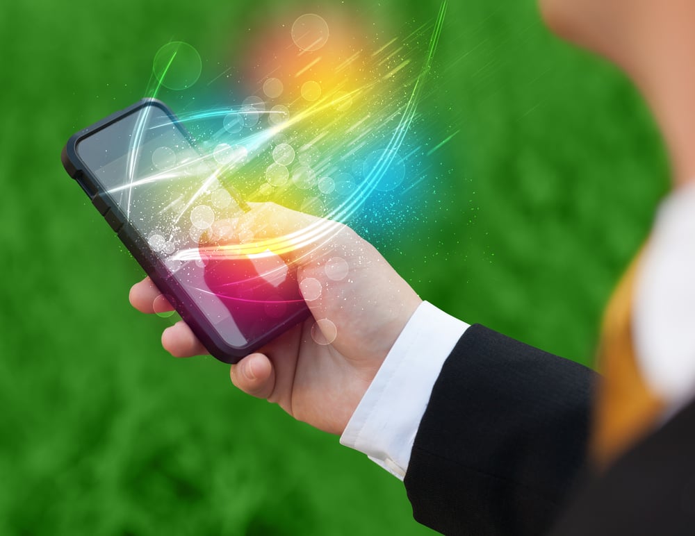 Hand holding smart phone with abstract glowing lines concept