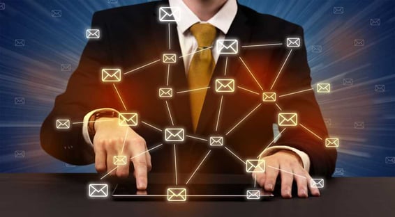 Man in suit typing with connected mail icons around