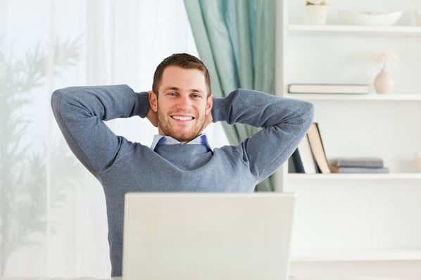 Smiling young businessman in his home office on virtual desktop